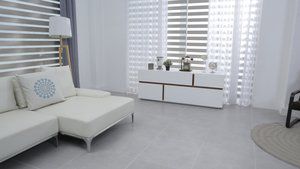 A living room with a white couch and a white dresser.
