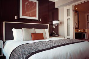A hotel room with a bed and a picture on the wall.